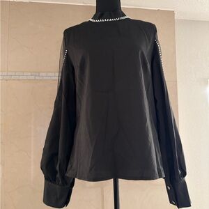 Beaded black top with a mesh sleeve. A great addition to your wardrobe. NWT
